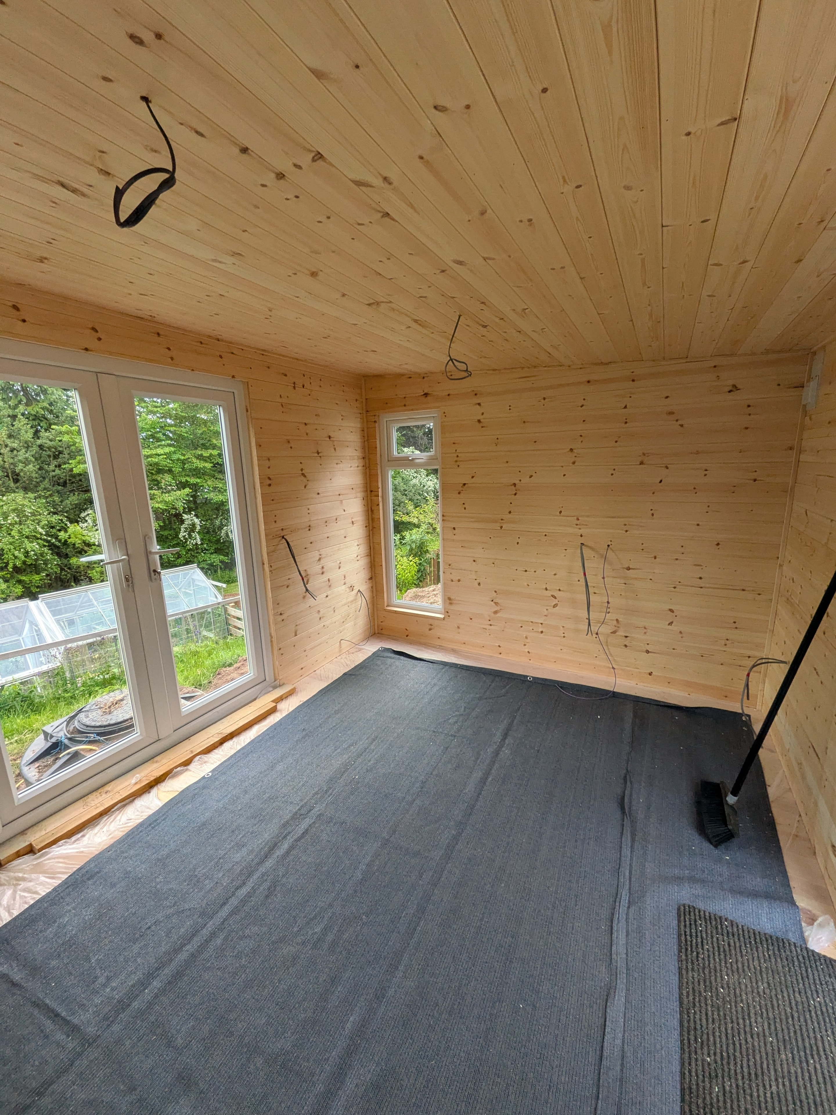 Timber-lined garden room interior with French doors