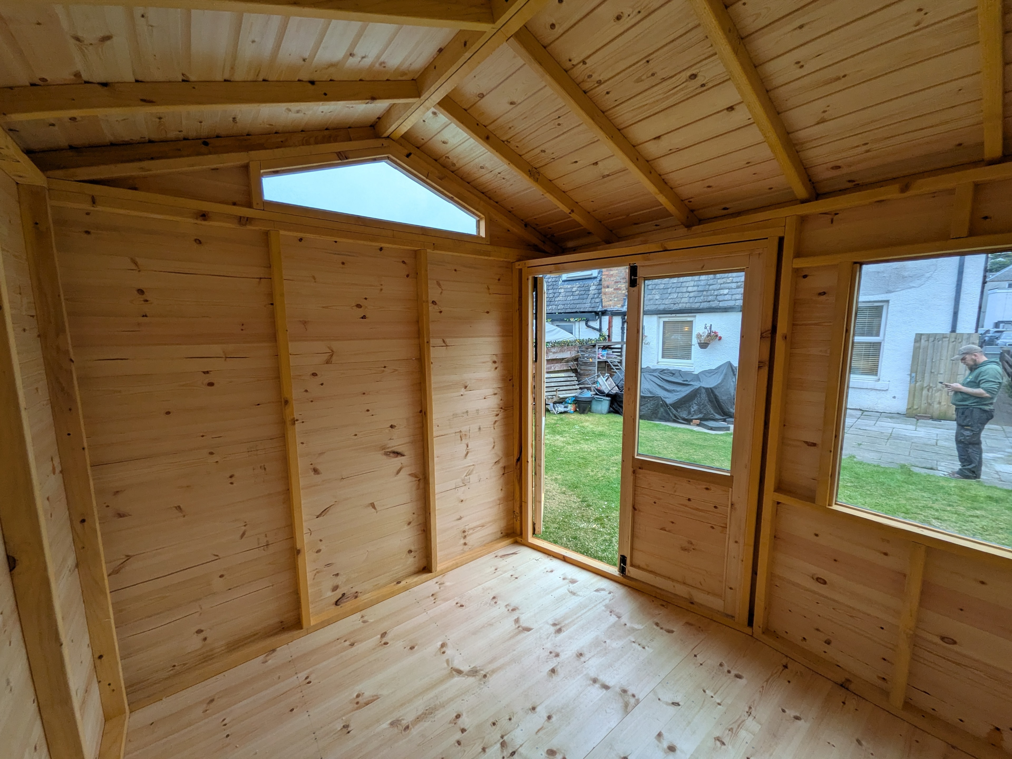 Timber summerhouse interior with vaulted ceiling and French doors