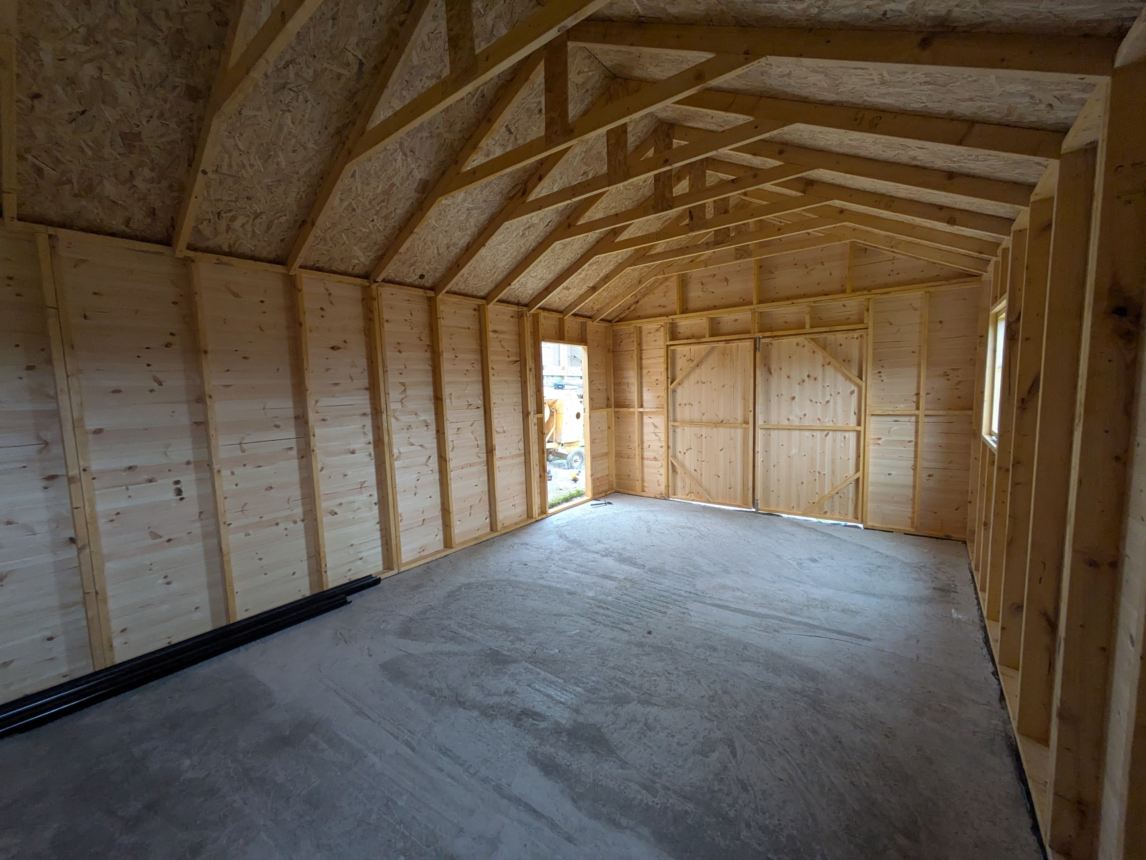 Timber workshop interior with vaulted roof and concrete floor